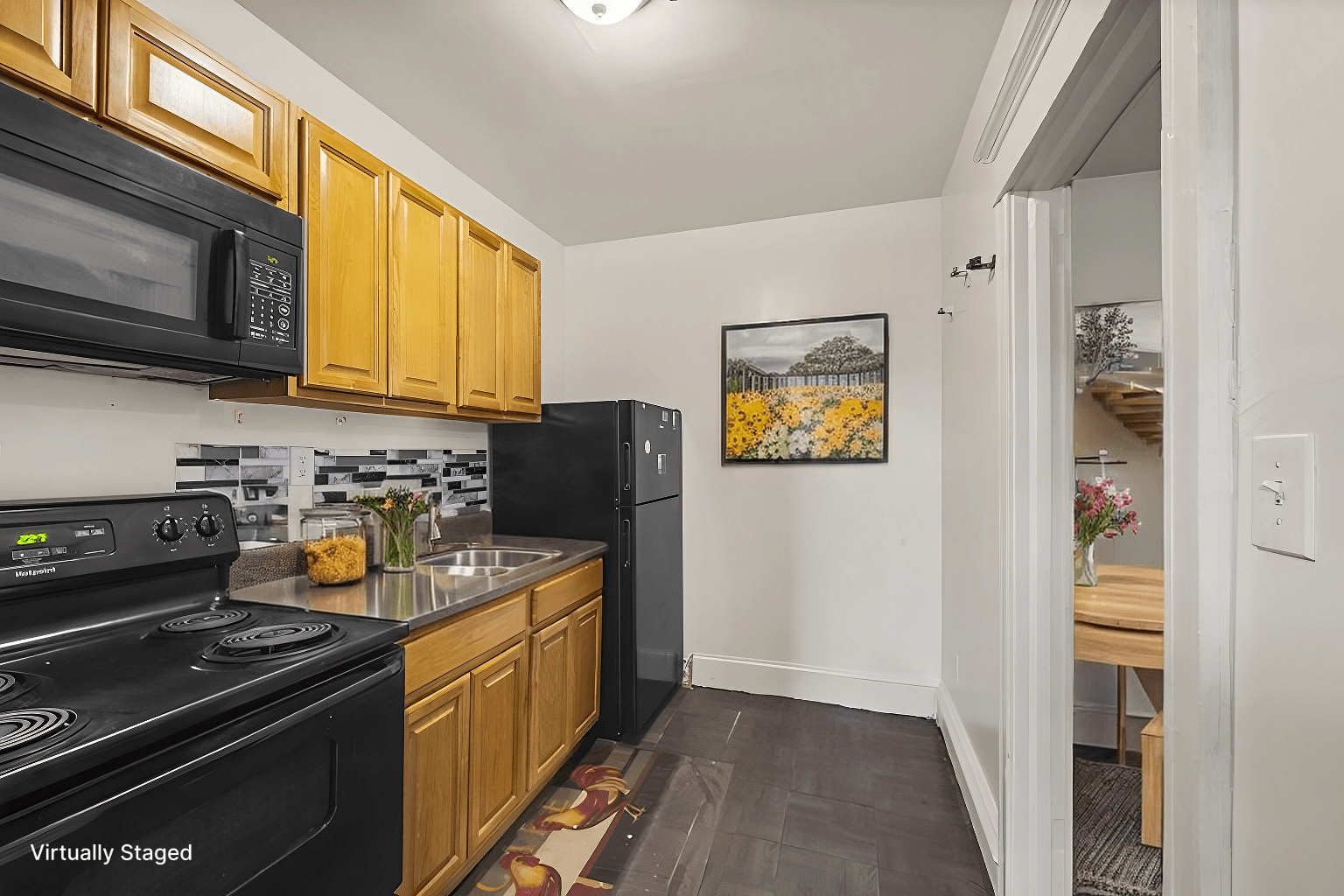 A kitchen with wooden cabinets and black appliances.